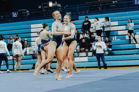 Delaney DeHaan and Deana Sheremeta celebrate the end of a successful floor routine