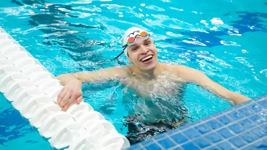 Karol Mlynarczyk smiling in the pool at the 2025 A-10 Championships
