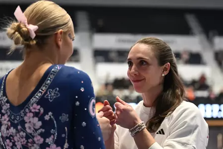 Stephanie Worrell gives Delaney DeHaan a pep talk before competing at Dare to Bloom meet.