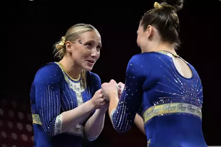 Delaney DeHaan and Deana Sheremeta wish each other good luck before competing on beam.