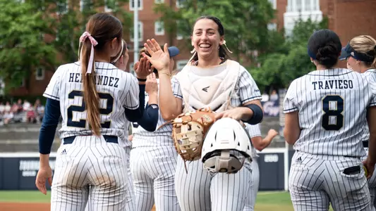 Allison Heffley walks through a line of high fives at the GW Softball Field