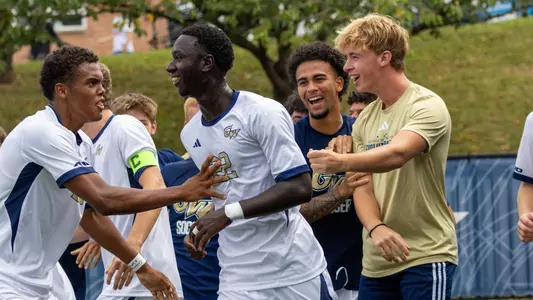 Babacar Fall celebrates his goal with teammates at the GW Soccer Field