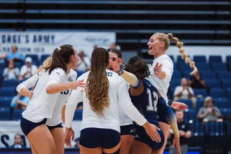 Volleyball huddles in the Smith Center against Loyola (MD)