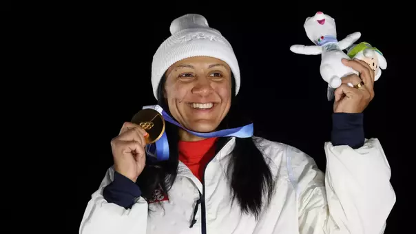 Elana Meyers Taylor holds up her gold medal in Cortina