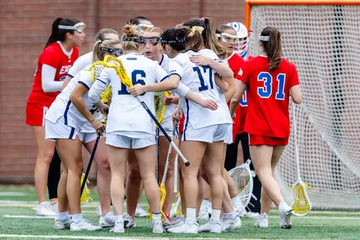 Lacrosse team huddles in game vs. American