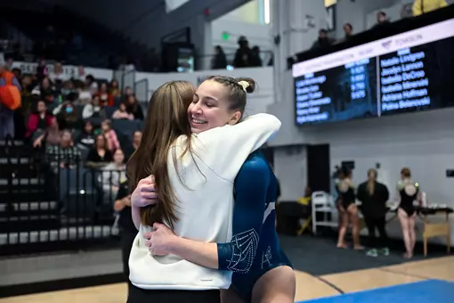 Nancy Kiner celebrates the end of her beam routine with Stephanie Worrell at the Smith Center