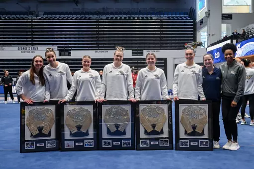 Seniors and GYM coaches pose together on senior night