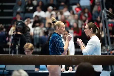 Lola Montevago gets ready to compete on beam with HC Stephanie Worrell