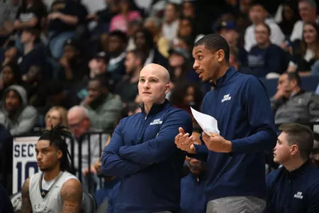 Aaron Thompson talks with Chris Caputo on the sideline during a game