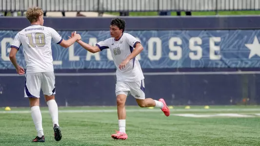 Miguel Sosa high fiving Finn Roberts at the GW Soccer Field