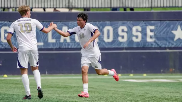 Miguel Sosa high fiving Finn Roberts at the GW Soccer Field