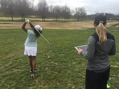 Sarfina Seretharan (left) works with Marshall women's golf coach Brooke Bellomy.
