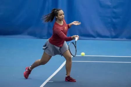 Liera Bender returns tennis ball to opponent.