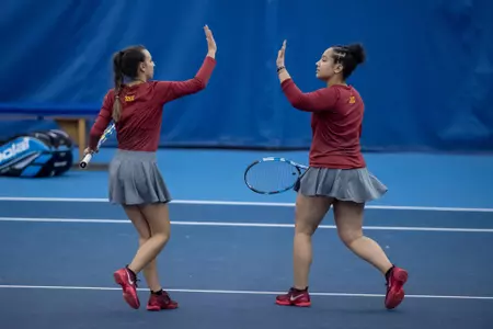 Athletes Erin Freeman and Annabella Bonadonna give each other a high five during their doubles match.