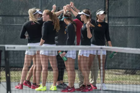 The Iowa State Tennis Team gathers in a huddle before the match begins.