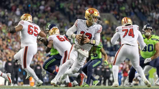 San Francisco 49ers quarterback Brock Purdy (13) rolls out against the Seattle Seahawks in an NFL football game, Thursday, Dec. 15, 2022, in Seattle Wash. (AP Photo/Jeff Lewis)