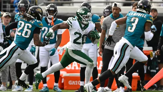 New York Jets running back Breece Hall (20) runs past Jacksonville Jaguars safety Antonio Johnson (26)and cornerback Tyson Campbell (3) during the second half of an NFL football game Sunday, Dec. 15, 2024, in Jacksonville, Fla. (AP Photo/Phelan M. Ebenhack)