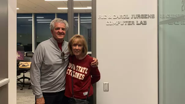 Ric and Carol Jurgens stand next to the athletics computer lab donning their name.
