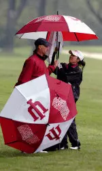 Indiana head coach Clint Wallman and junior Jenny Kim bombard the rain while discussing strategy during Sunday's final round of the 2006 Big Ten Championships.