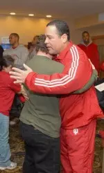 Coach Kelvin Sampson is embraced by Gary Kemp