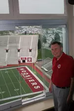 Mark Deal stands in a suite with one sliding glass window open