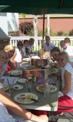 The team enjoys a pre-game meal on an outside patio under sunny skies