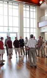Head football coach Bill Lynch gives a tour of the Henke Hall of Champions in the North End Zone Student-Athlete Development Center.