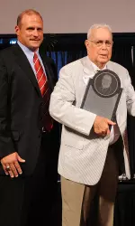 Dr. Charles Van Tassel, right, is presented with the inaugural plaque of the award given in his honor. The inaugural Dr. Charles Van Tassel Award was given to Larry Glaubinger and to Bill and Gayle Cook. At left is Joe Ford, president and chairman of the Varsity Club National Board of Directors.