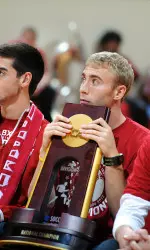 Senior co-captain Caleb Konstanski takes care of the NCAA Championship trophy at tonight's Celebrate Eight gathering.