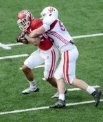 Linebacker Jake Michalek wraps up wide receiver Cody Latimer at Thursday's practice.