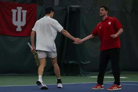 BLOOMINGTON, IN - February 9, 2024 - senior Michael Andre of the Indiana Hoosiers and Head Coach Jeremy Wurtzman of the Indiana Hoosiers during the meet between the Drake Bulldogs and the Indiana Hoosiers at IU Tennis Center in Bloomington, IN. Photo By Levi Jones/Indiana Athletics