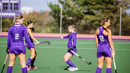 Sydney Raguini & Lilly Turner dancing before the opening whistle against Ohio on the field at the JMU Field Hockey Complex