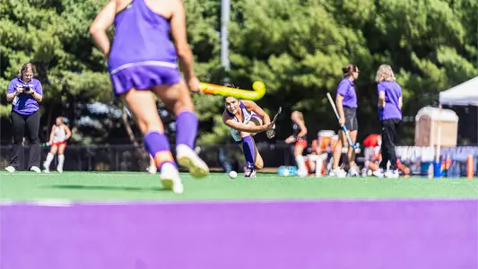 Callen Todd passing a ball during pregame warmups before playing Ball State at the JMU Field Hockey Complex