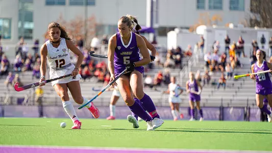 Maddie Tierney dribbling upfield against Central Michigan at the JMU Field Hockey Complex