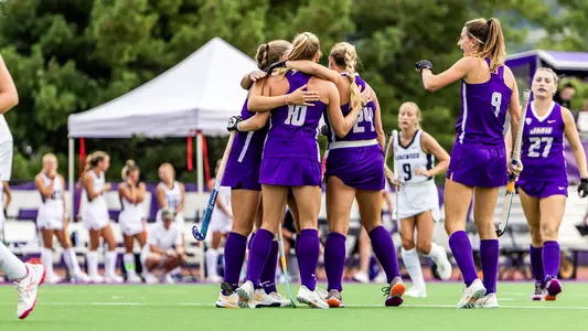 Alice Roeper, Madelief Molier, and Julie Narleski wrap their arms around each other after a goal against Longwood at the JMU Field Hockey Complex