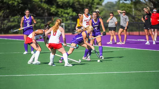 Sophia Walch dribbling through defenders near the sidelines versus Ball State at the JMU Field Hockey Complex