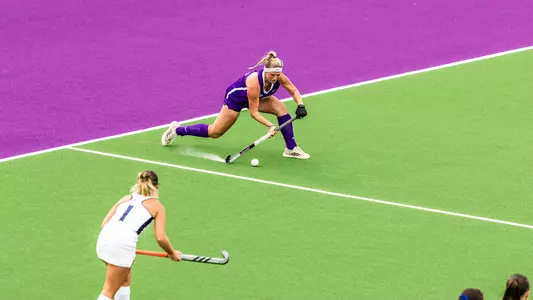 Jola Ollrogge passing across the field against Longwood at the JMU Field Hockey Complex