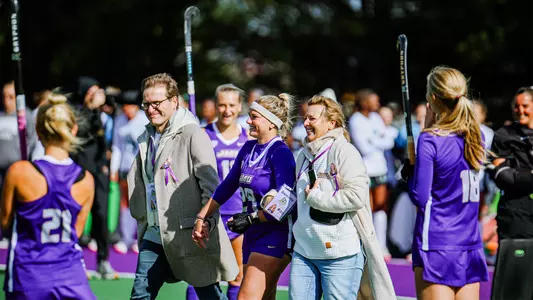 Jola Ollrogge walking with family down the midfield line during the Senior Day Ceremony at the JMU Field Hockey Complex