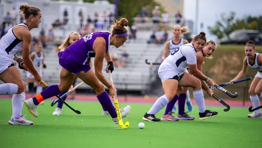 Skyler Brown drives into the circle, about to pass inside to a teammate against Longwood at the JMU Field Hockey Complex