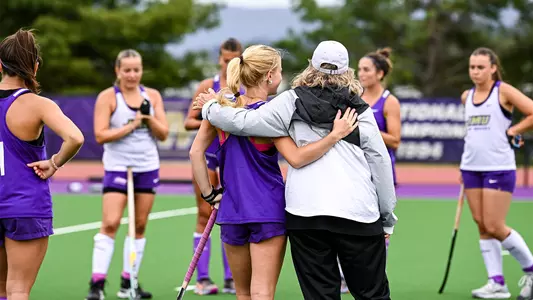 Sophia Walch and Christy Morgan with arms around each other with their backs to the camera at practice