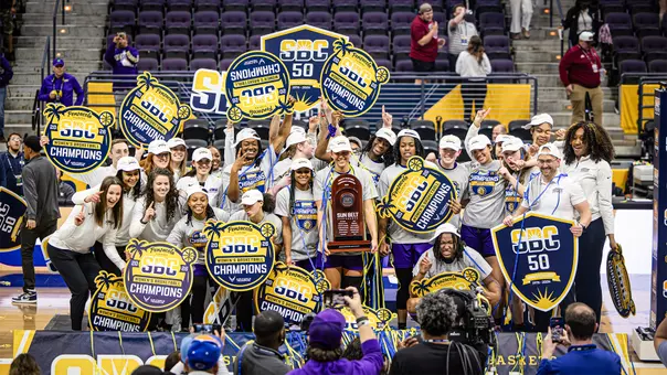 Women's basketball celebrates with Sun Belt trophy and signage at the Sun Belt Conference Championship at the Pensacola Bay Center
