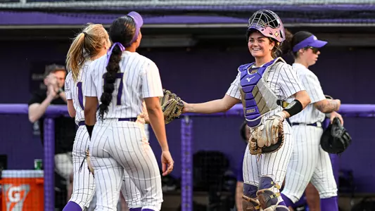 Softball players high five after a win.