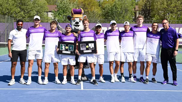 JMU seniors Esteve Agusti and Francisco Sinopoli pose for a Senior Day photo with their teammates, coaches and Duke Dog at Hillside Courts.