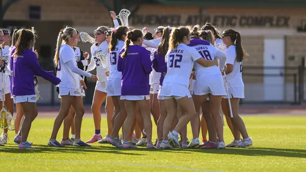 JMU Lacrosse celebrates after defeating Georgetown.