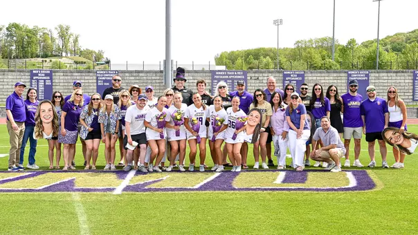 The 2026 JMU Lacrosse seniors and their families pose for a photo ahead of their game against Vanderbilt.