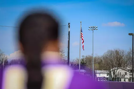James Madison softball player looking at the American flag.