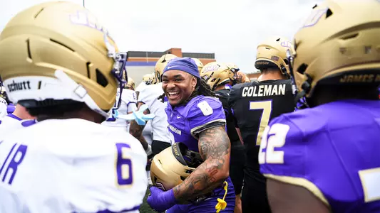 Amar Thomas speaking to players on the field before Spring Game at Bridgeforth Stadium.