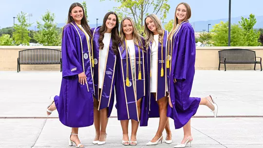 2026 JMU Lacrosse Grads posing during their Student Athlete graduation