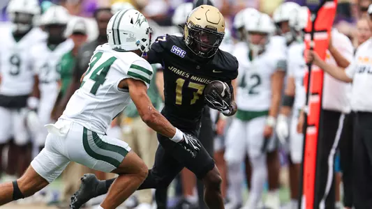 Michael Scott stiff arms a Wagner defender during a punt return