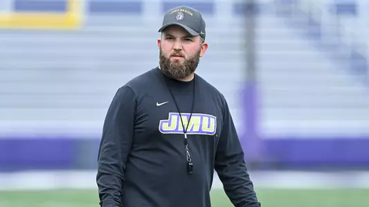 Mason Collins coaches during a JMU football practice